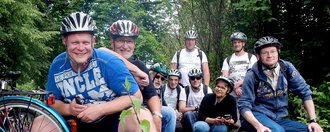 Gruppenfoto mit Fahrrad - alle Frauen und Männer tragen einen Fahrradhelm